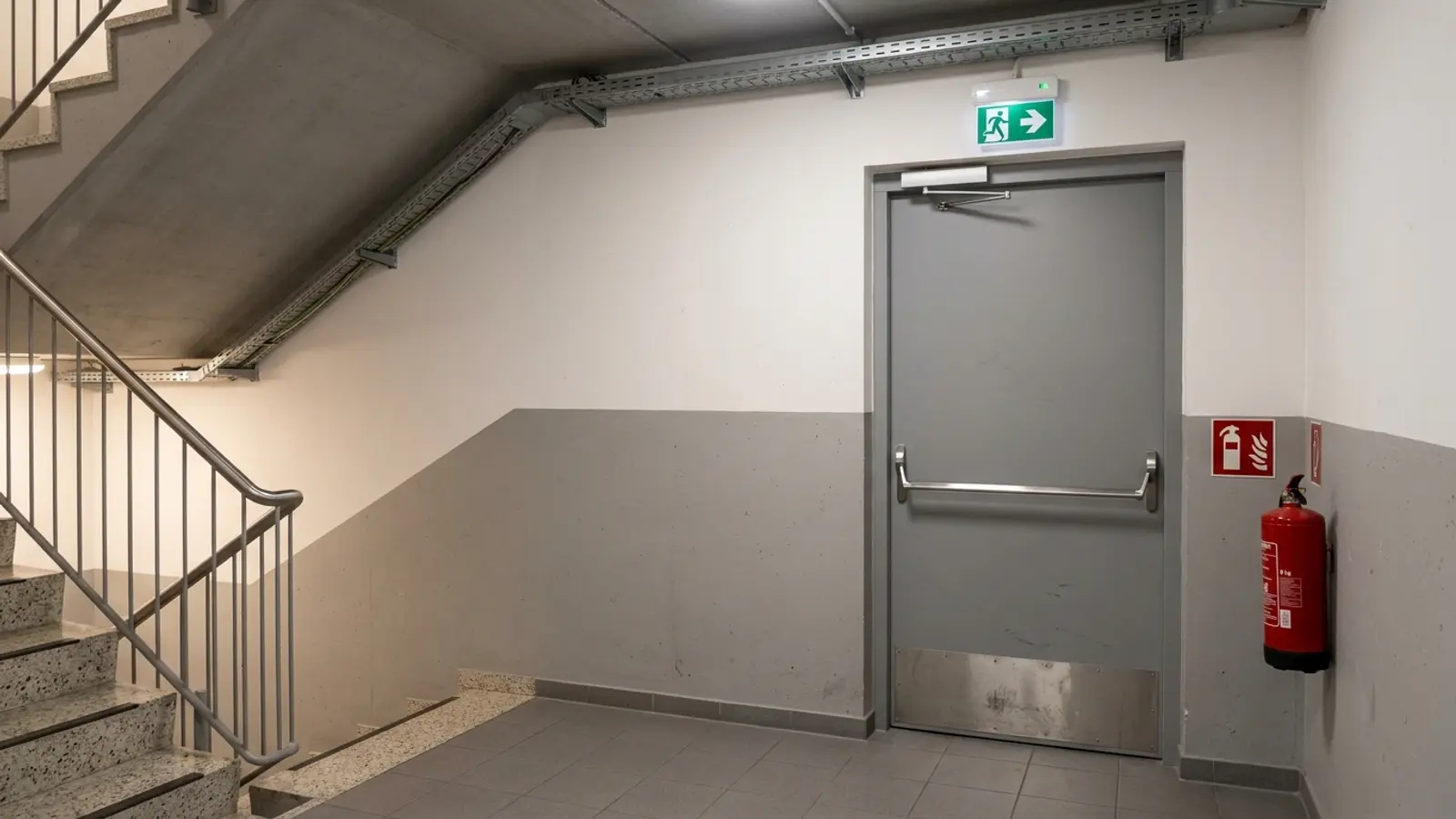 Técnico instalando una puerta cortafuego en un garaje comunitario